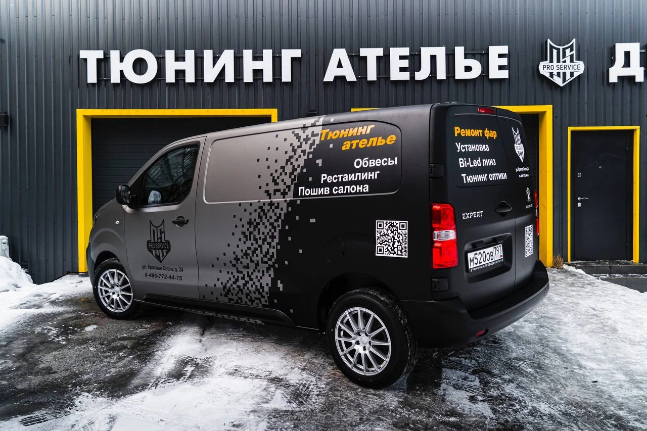 Peugeot Expert с фирменной графикой со стороны задней части: надписи на дверях и боковине, снег на площадке.