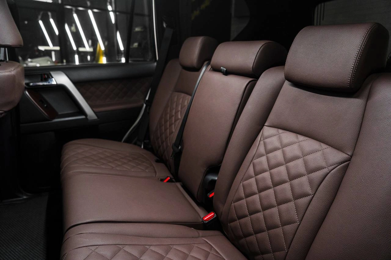 Коричневые задние сиденья Toyota Land Cruiser Prado с ромбовидной строчкой на центральных вставках.