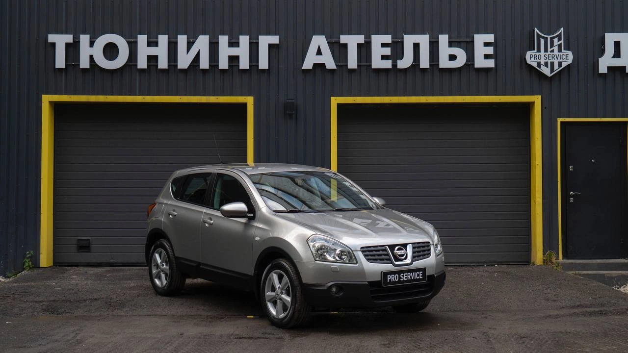 Серебристый Nissan Qashqai у ателье PRO Service, вид спереди сбоку.