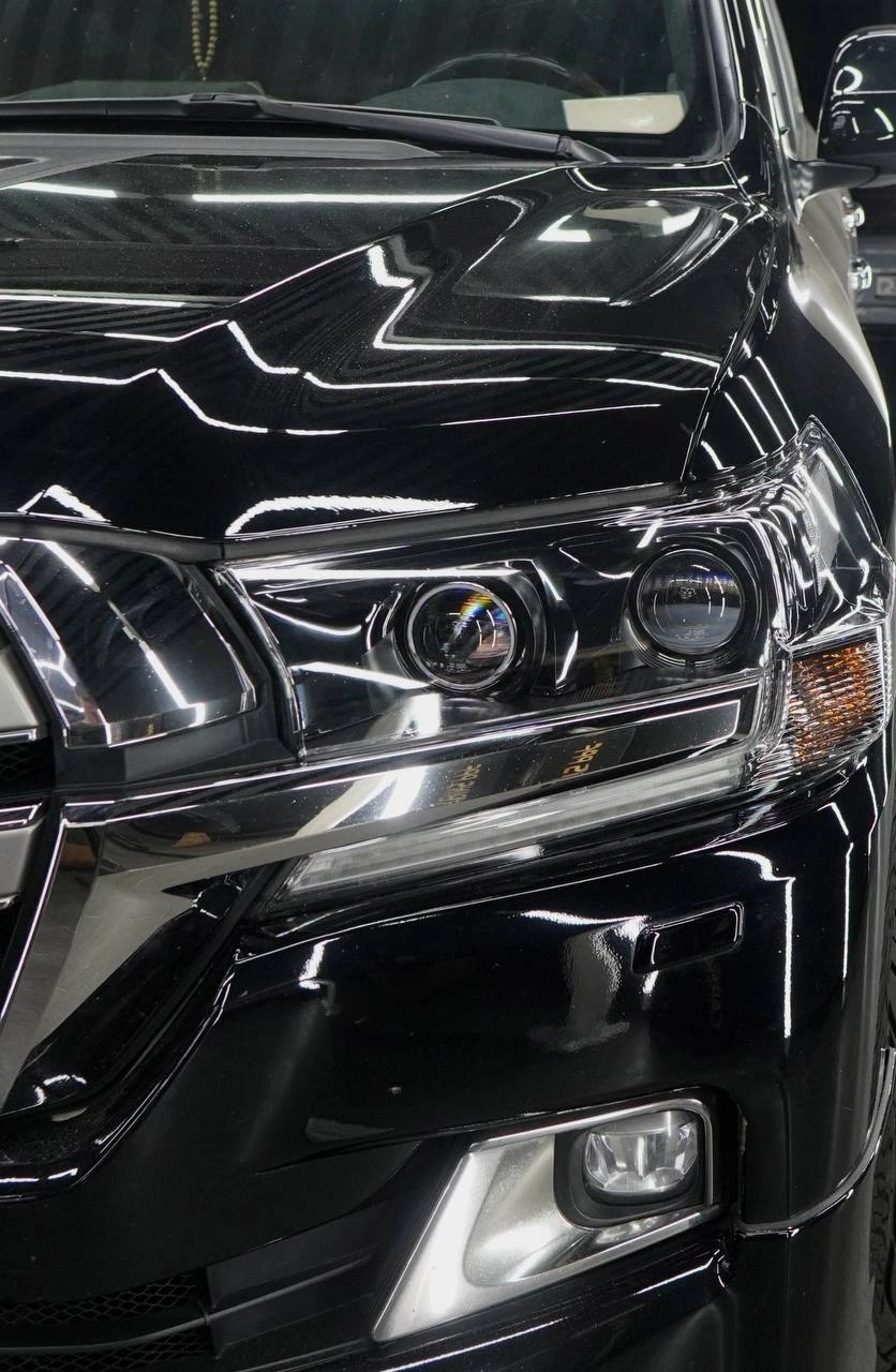 Toyota Land Cruiser 200 — передняя фара и хромированная окантовка решётки радиатора крупным планом