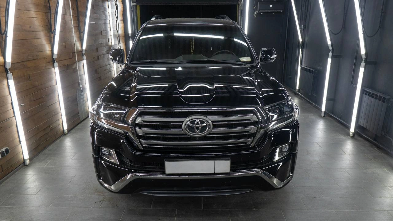 Toyota Land Cruiser 200 — чёрный внедорожник с хромированной решёткой радиатора, вид спереди