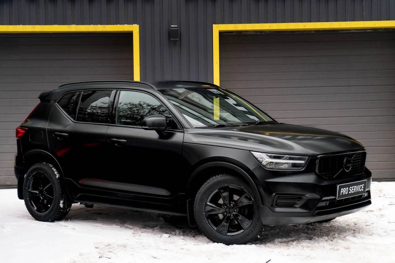 Боковой профиль Volvo XC40 с матовым кузовом и чёрными колёсными дисками.