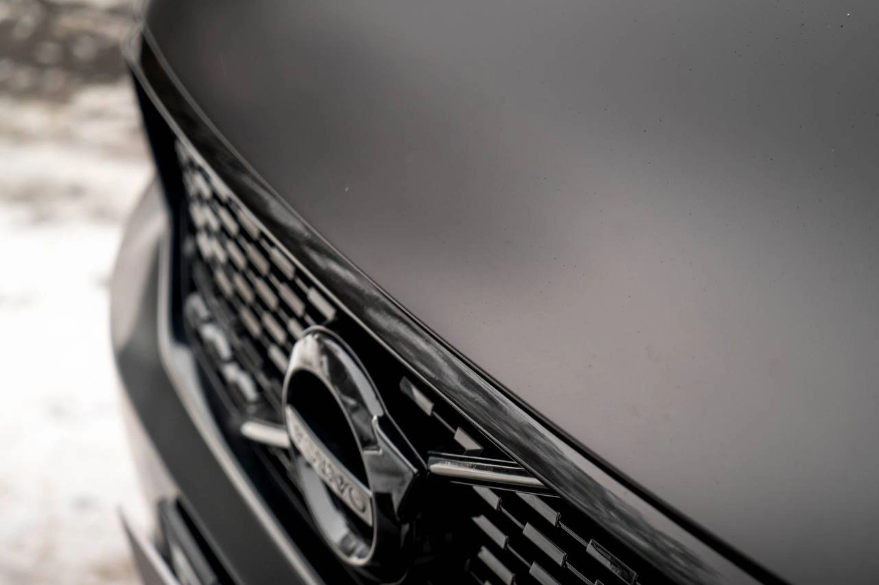 Матовая поверхность капота Volvo XC40 и чёрная решётка радиатора крупным планом.