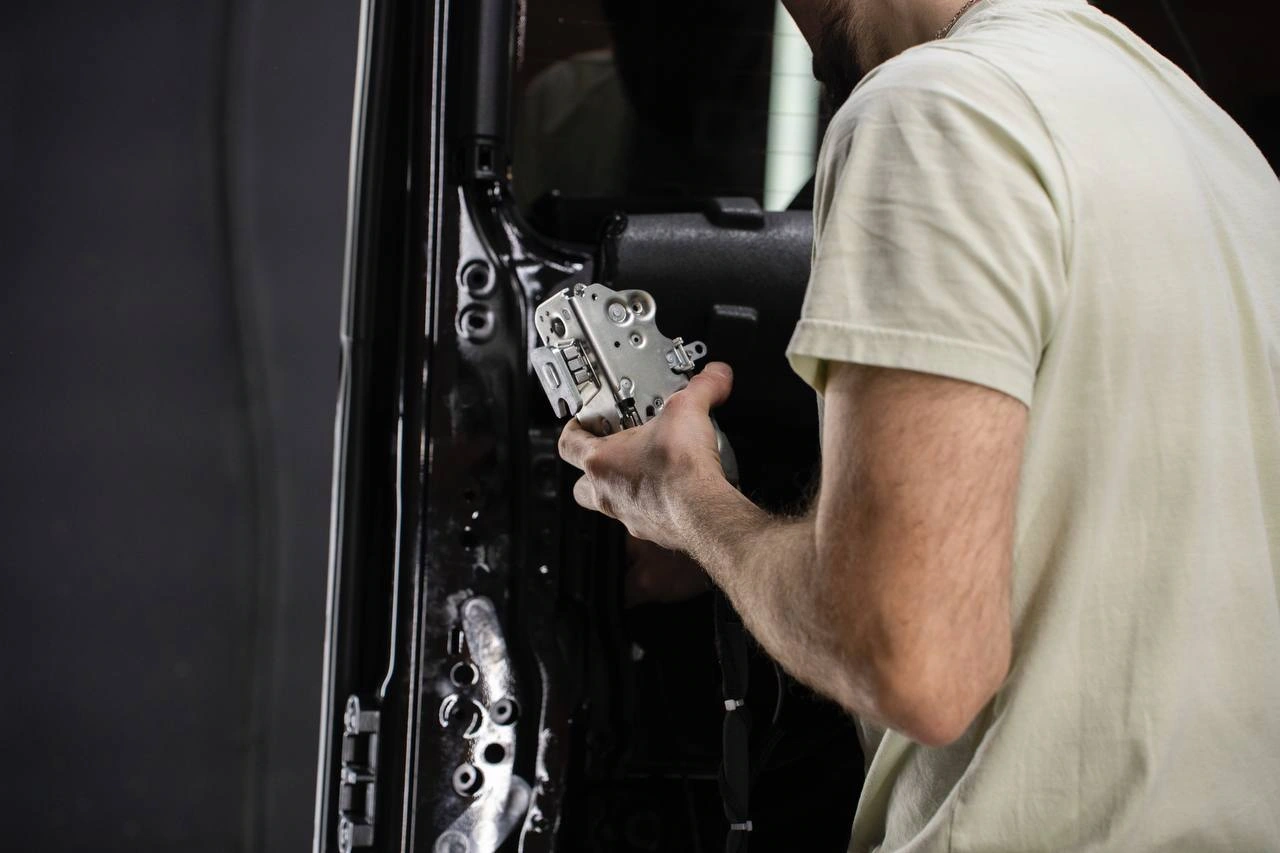 Мастер работает с механизмом двери Mercedes-Benz G-class при снятой внутренней обшивке.