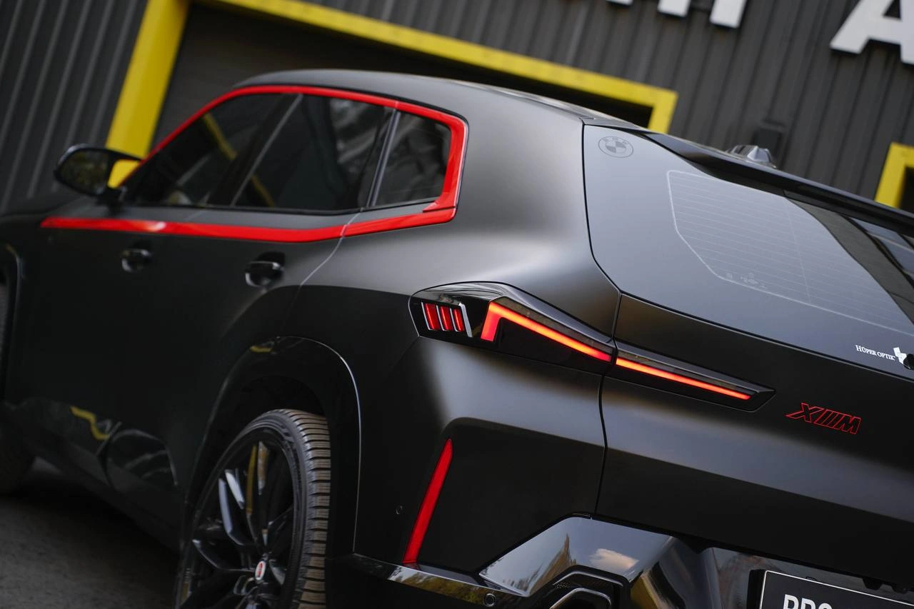 Заднее крыло и фонарь BMW XM с матовой плёнкой и красной отделкой.