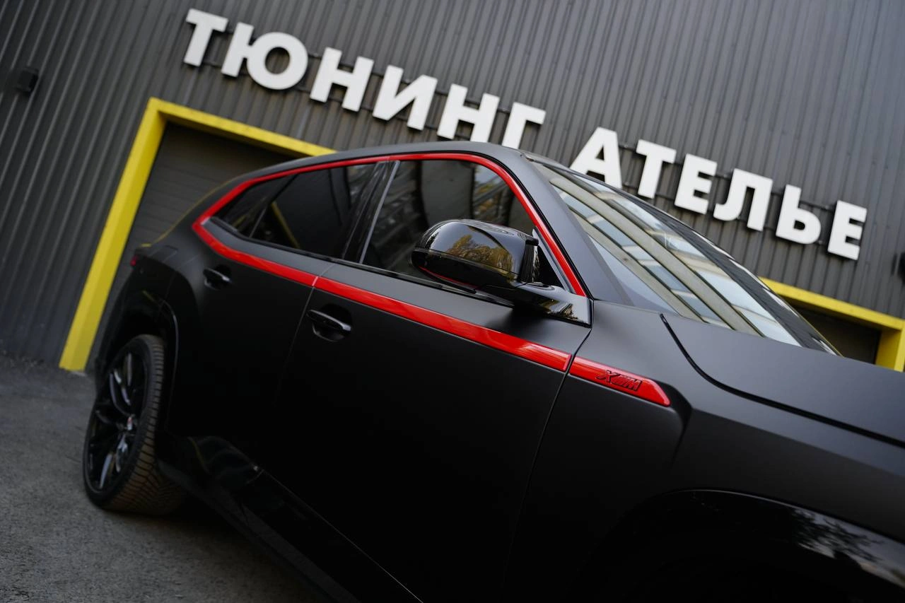 Боковая часть BMW XM с матовой плёнкой и красными молдингами вокруг окон.