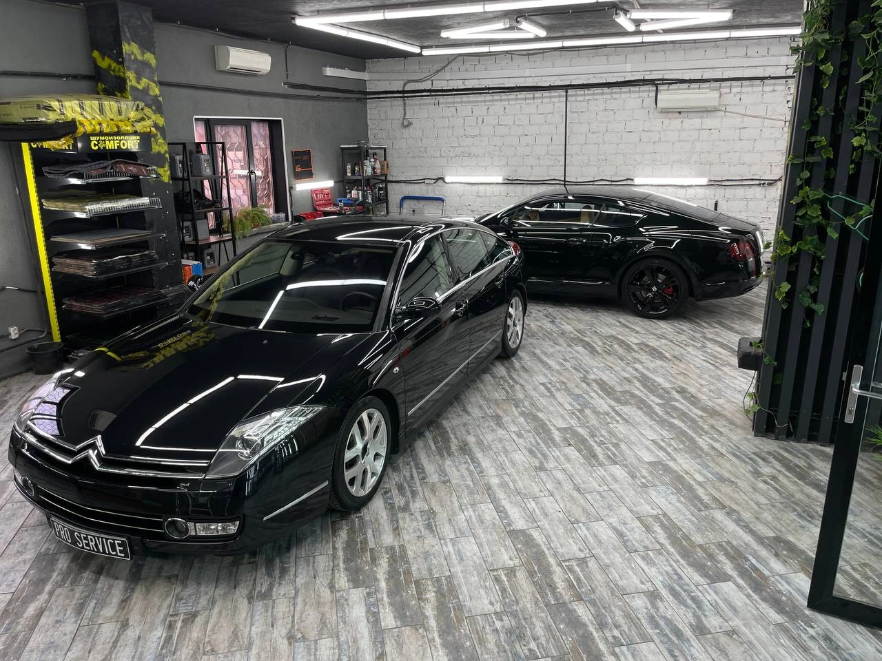 Citroen C6 — тёмный седан спереди под углом в студии, на заднем плане стоят другие автомобили