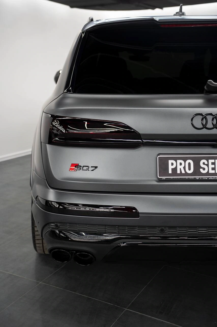 Задняя часть Audi SQ7: матовый кузов, тёмные фонари и насадки выхлопной системы.