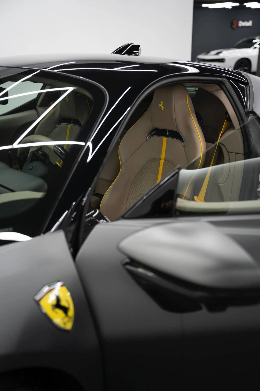 Ferrari SF90 Stradale — открытая дверь спорткара и светлая обивка сиденья в салоне