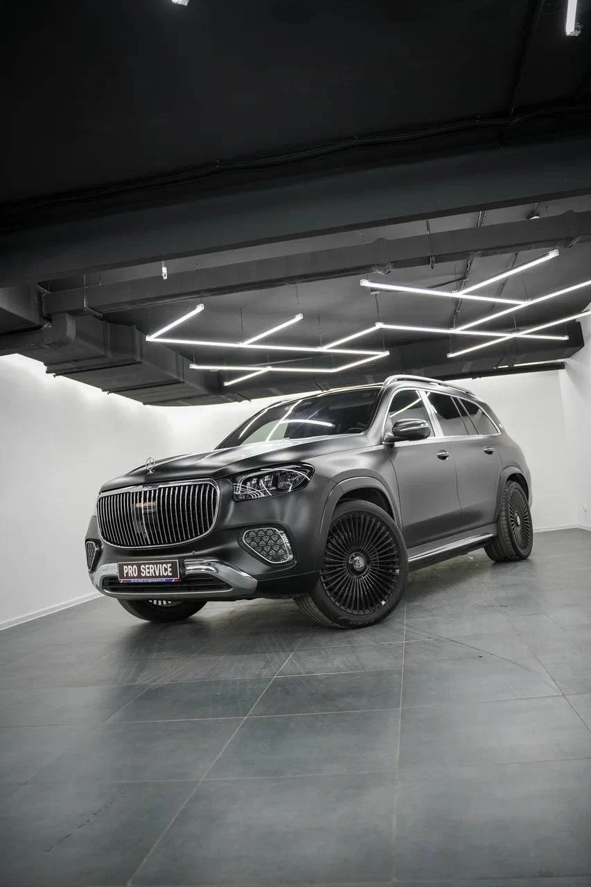 Mercedes-Benz GLS Maybach в светлом боксе: вид спереди и сбоку, светлый кузов, тёмная крыша и колёса.