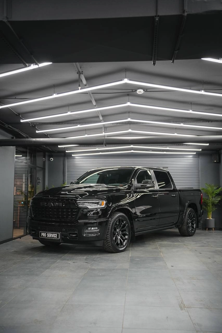 Чёрный пикап Dodge Ram после защиты зон риска полиуретановой плёнкой, вид спереди сбоку.