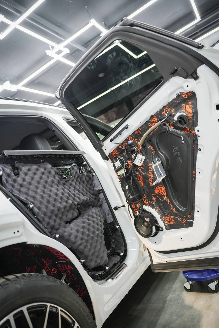 Дверь Geely Tugella со снятой обшивкой: изоляционные листы на панели и оборотная сторона дверной карты.