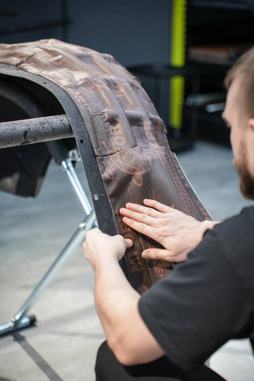 Mercedes-Benz G-Class — мастер прикатывает изоляционный материал к внутренней поверхности подкрылка