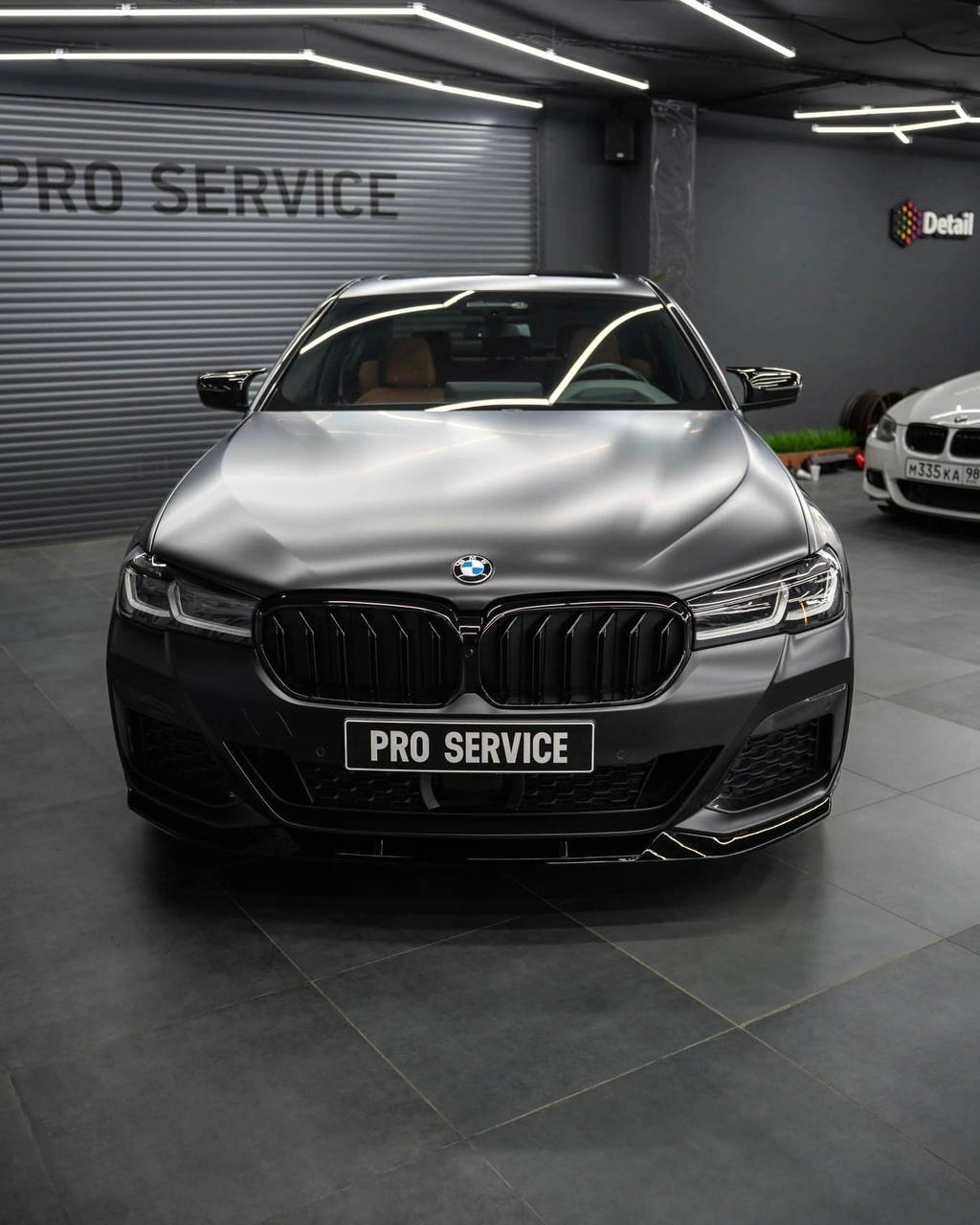 BMW 5 G30 — вид спереди с серым капотом, фарами и чёрной решёткой радиатора