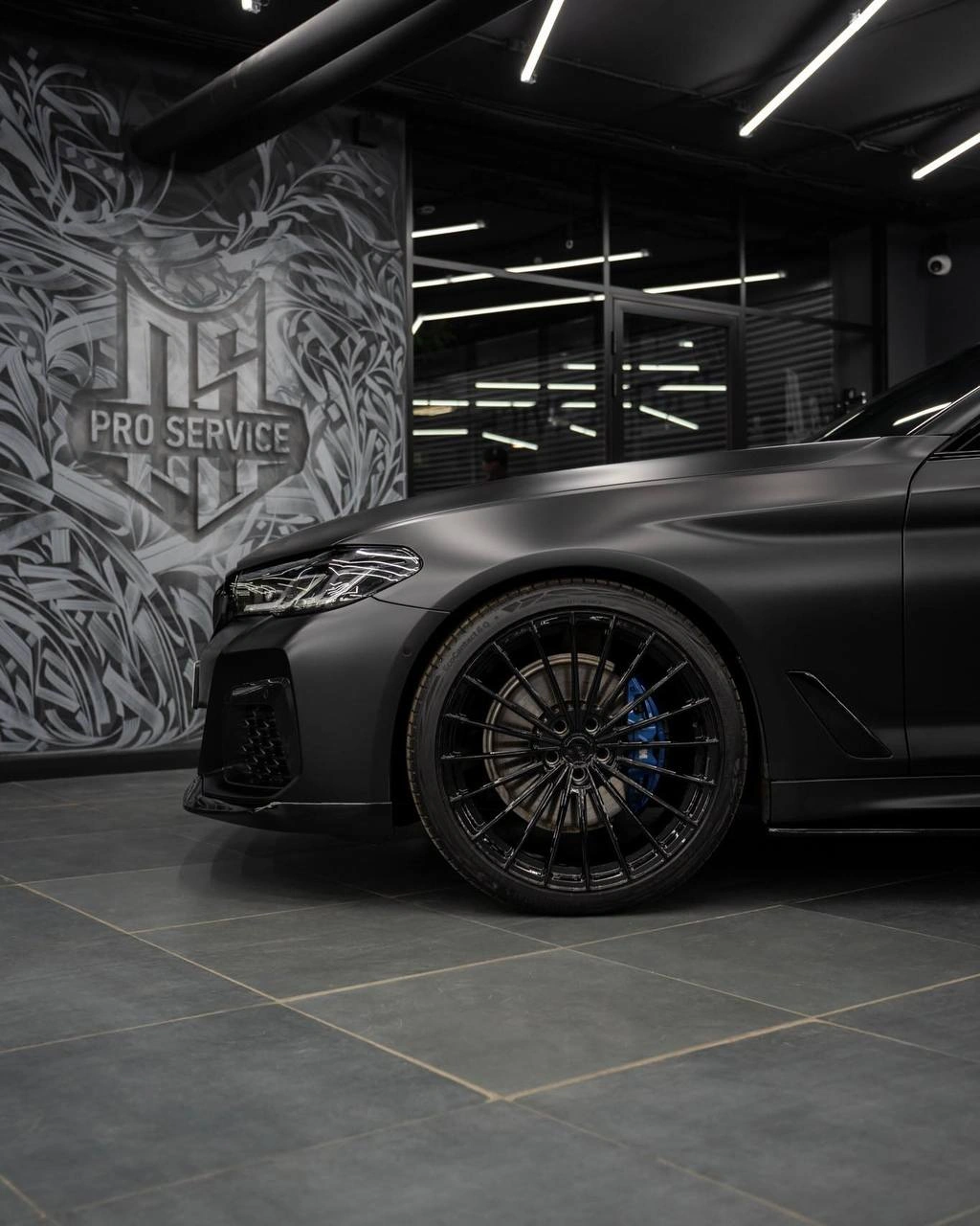 BMW 5 G30 — переднее многоспицевое колесо, тормозной суппорт и боковина серого кузова