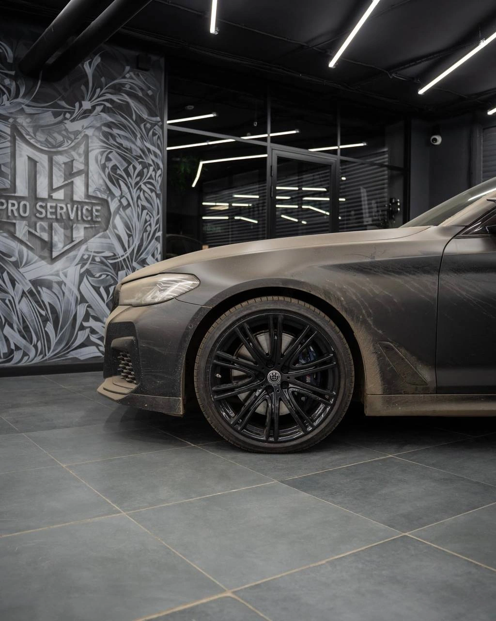 Переднее крыло и колесо BMW 5 G30 сбоку: на кузове и диске видны загрязнения и пыль.