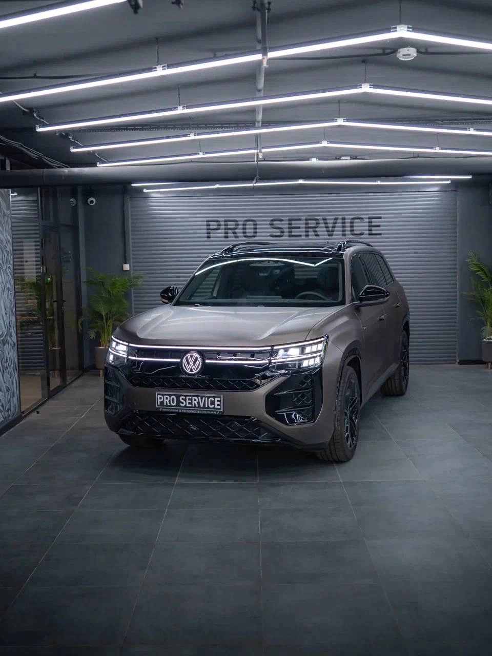 Volkswagen Teramont — общий вид спереди под углом под световыми линиями студии