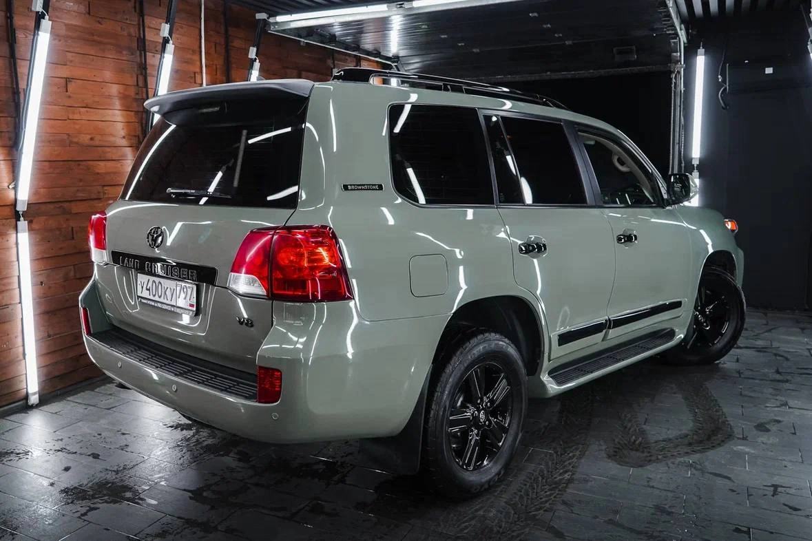 Toyota Land Cruiser 200 — вид сзади под углом, задние фонари и боковая линия светлого кузова