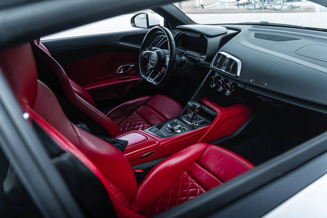 Audi R8 — салон с красной обивкой сидений и дверей, руль и центральная консоль