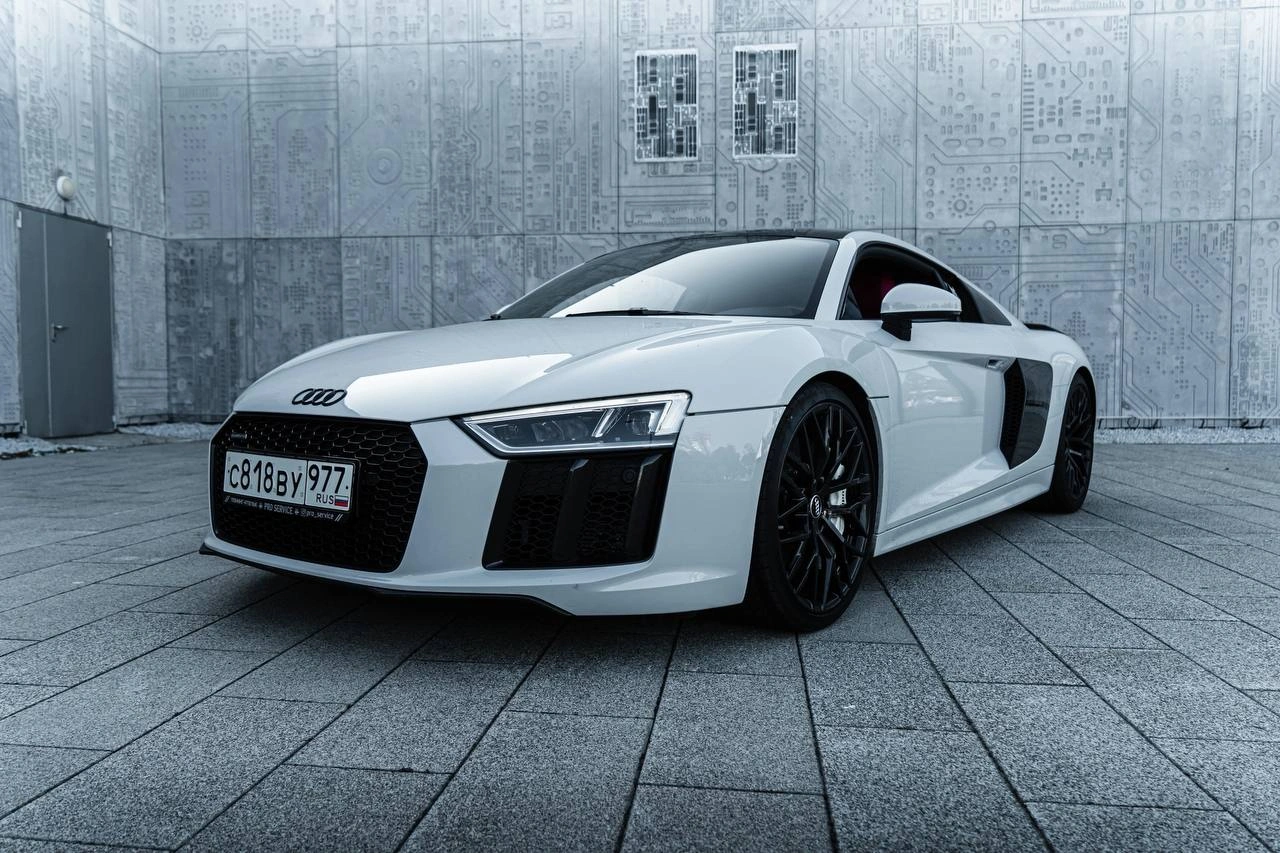 Audi R8 — белый спорткар спереди под углом на серой мощёной площадке