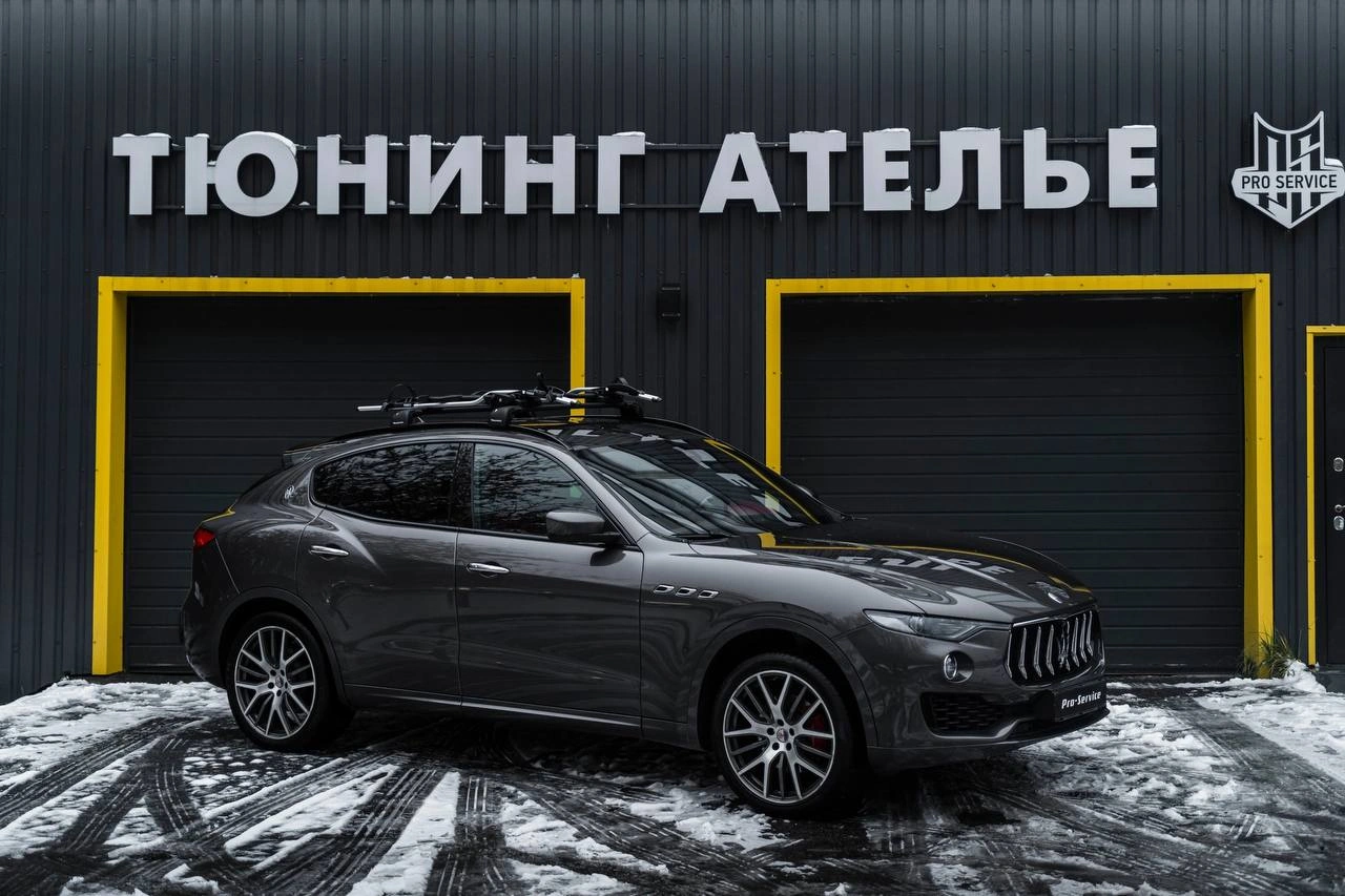 Maserati Levante — серый кроссовер с багажной системой на крыше перед тюнинг-ателье